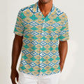 Button-down shirt featuring the Bloomgrid in Capri Coast pattern, with a blue coastal floral grid design and all-over print. Lightweight casual shirt with retro resort style, beach vacation fashion, botanical pattern, geometric floral print, artsy summer outfit, coastal grandma aesthetic, indie fashion, colorful resortwear, short sleeve statement shirt, vacation button down, breezy warm weather clothing, and unique patterned apparel for beach days, brunch, travel, festivals, and everyday summer wear.