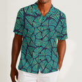 Button-down shirt featuring the Frondescence pattern with layered tropical foliage in deep green botanical tones and an all-over nature-inspired print. Lightweight summer shirt with lush jungle aesthetic, maximalist fashion, indie streetwear, botanical artwork, earthy resort style, expressive queer friendly fashion, artsy casualwear, and retro-inspired tropical clothing perfect for vacations, festivals, brunch, beach trips, and everyday alternative wear.