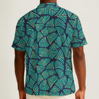 Button-down shirt featuring the Frondescence pattern with layered tropical foliage in deep green botanical tones and an all-over nature-inspired print. Lightweight summer shirt with lush jungle aesthetic, maximalist fashion, indie streetwear, botanical artwork, earthy resort style, expressive queer friendly fashion, artsy casualwear, and retro-inspired tropical clothing perfect for vacations, festivals, brunch, beach trips, and everyday alternative wear.