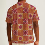Button-down shirt featuring the Petal Circuit in Mulled Spice pattern with warm rust, cream, plum, and golden geometric floral shapes in a retro-inspired all-over print. Lightweight statement shirt with vintage autumn aesthetic, maximalist fashion, indie streetwear, mod inspired design, expressive queer friendly style, artsy casualwear, and colorful resortwear perfect for festivals, travel, brunch, concerts, and everyday alternative summer wear.