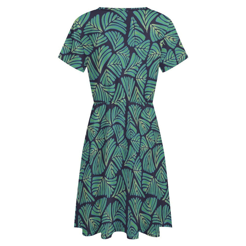 Short sleeve dress featuring the Frondescence pattern with layered tropical foliage in deep green botanical tones and an all-over nature-inspired print. Flowy casual dress with earthy jungle aesthetic, maximalist fashion, indie streetwear, botanical artwork, expressive queer friendly style, artsy everyday wear, and retro-inspired tropical clothing perfect for vacations, brunch, festivals, casual outings, and comfortable everyday alternative fashion.
