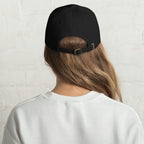 Baseball cap embroidered with the phrase ‘I Have a Cigarette in All 7 Holes’ in ornate vintage gothic lettering. Alternative fashion accessory with edgy internet humor, queer streetwear aesthetic, punk inspired style, ironic meme fashion, tattoo inspired typography, goth streetwear, adjustable dad hat, casual alternative outfit accessory, artsy statement cap, chaotic humor apparel, indie fashion, and expressive alternative clothing for concerts, festivals, everyday wear, and alternative wardrobes.