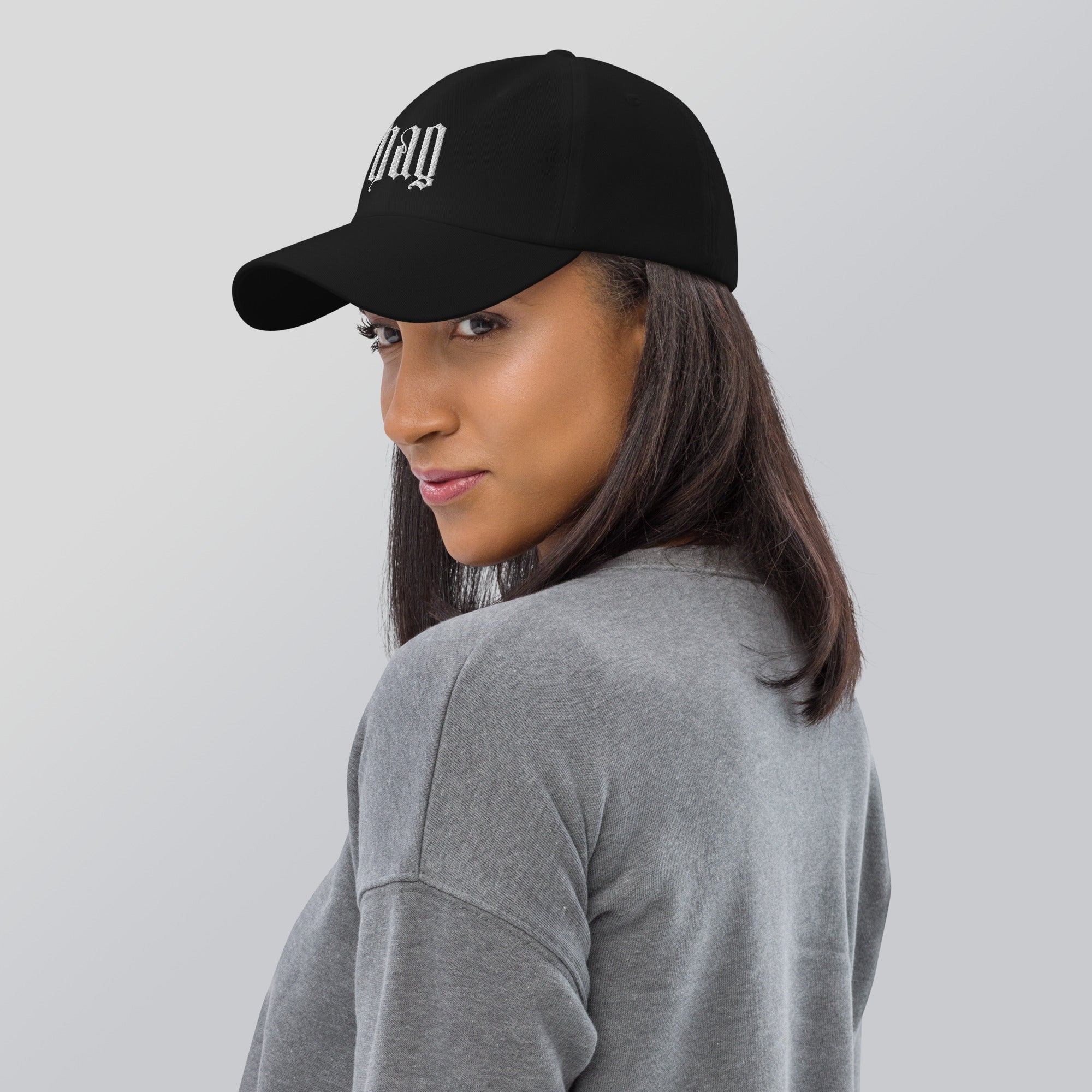 Black dad hat embroidered with the word ‘HAG’ in ornate vintage gothic lettering. Alternative fashion accessory with queer streetwear aesthetic, witchy fashion, sarcastic humor, feminist style, indie fashion, spooky cute apparel, gothic embroidery, punk inspired streetwear, adjustable baseball cap, casual everyday alternative outfit, internet humor fashion, artsy accessory, and edgy statement hat for concerts, festivals, casual wear, and alternative wardrobes.