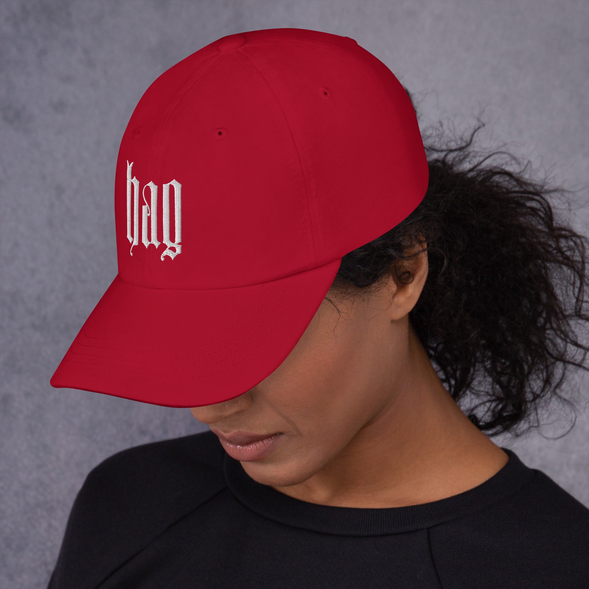 Black dad hat embroidered with the word ‘HAG’ in ornate vintage gothic lettering. Alternative fashion accessory with queer streetwear aesthetic, witchy fashion, sarcastic humor, feminist style, indie fashion, spooky cute apparel, gothic embroidery, punk inspired streetwear, adjustable baseball cap, casual everyday alternative outfit, internet humor fashion, artsy accessory, and edgy statement hat for concerts, festivals, casual wear, and alternative wardrobes.