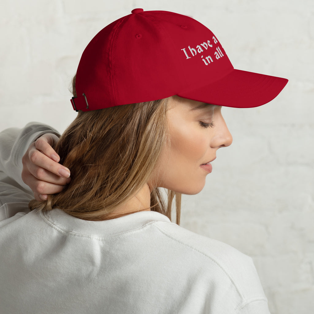 Baseball cap embroidered with the phrase ‘I Have a Cigarette in All 7 Holes’ in ornate vintage gothic lettering. Alternative fashion accessory with edgy internet humor, queer streetwear aesthetic, punk inspired style, ironic meme fashion, tattoo inspired typography, goth streetwear, adjustable dad hat, casual alternative outfit accessory, artsy statement cap, chaotic humor apparel, indie fashion, and expressive alternative clothing for concerts, festivals, everyday wear, and alternative wardrobes.