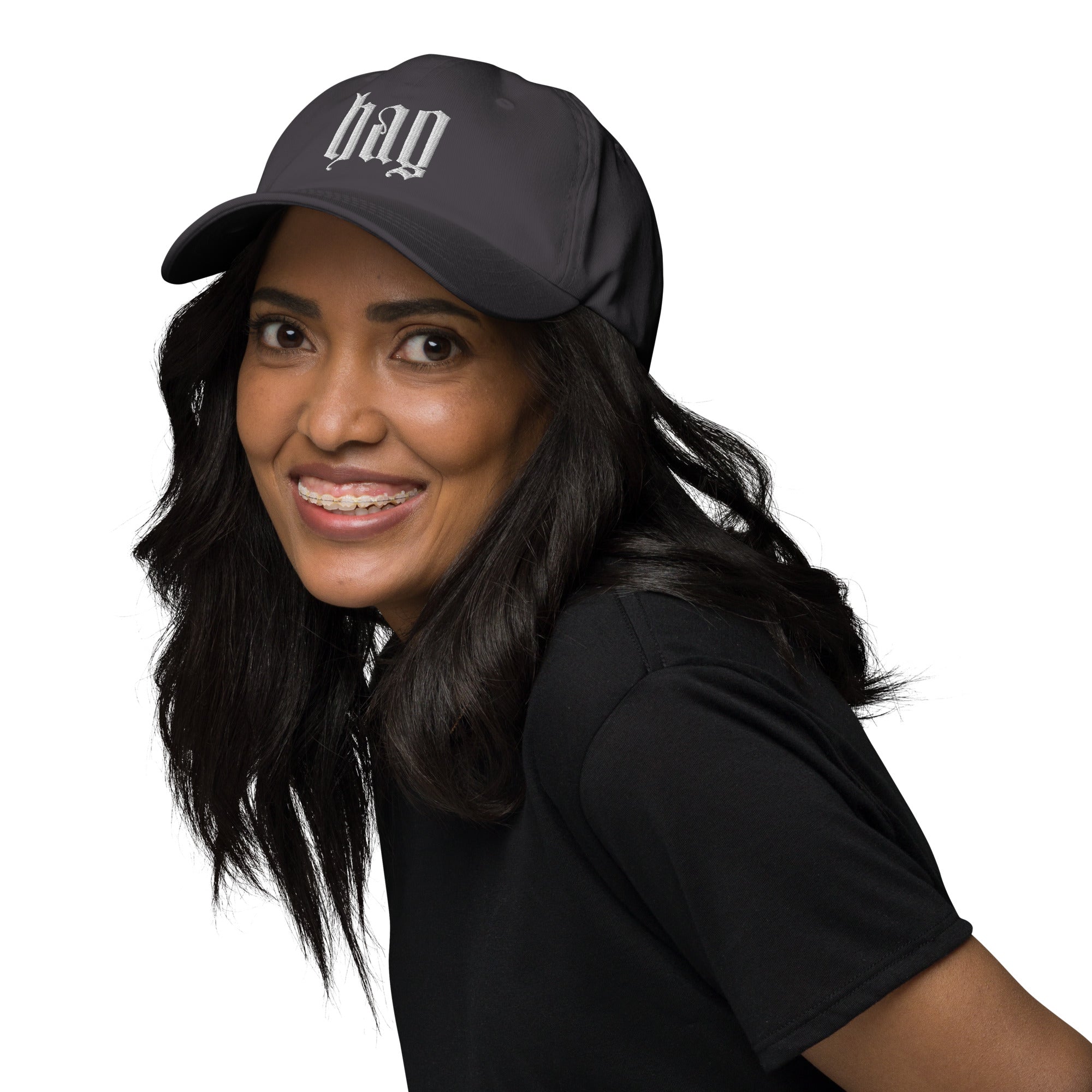 Black dad hat embroidered with the word ‘HAG’ in ornate vintage gothic lettering. Alternative fashion accessory with queer streetwear aesthetic, witchy fashion, sarcastic humor, feminist style, indie fashion, spooky cute apparel, gothic embroidery, punk inspired streetwear, adjustable baseball cap, casual everyday alternative outfit, internet humor fashion, artsy accessory, and edgy statement hat for concerts, festivals, casual wear, and alternative wardrobes.