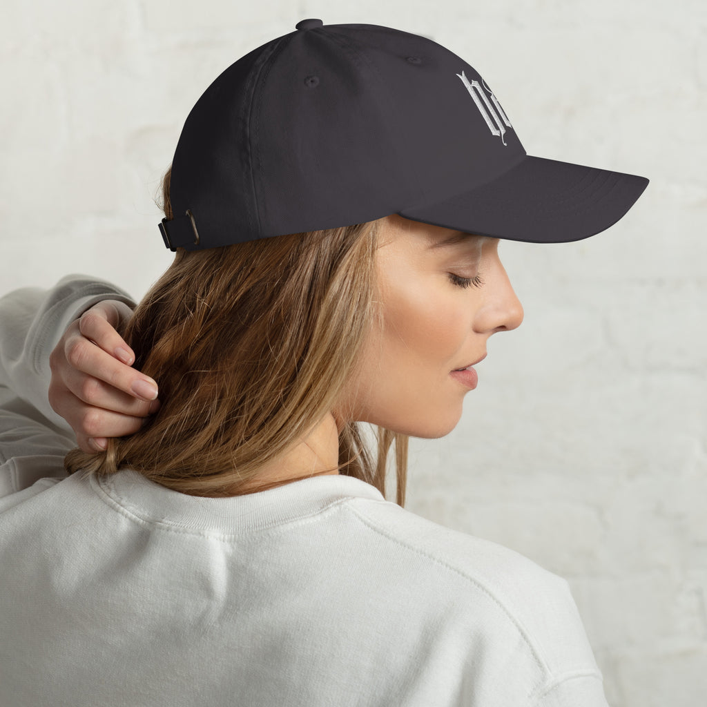 Black dad hat embroidered with the word ‘HAG’ in ornate vintage gothic lettering. Alternative fashion accessory with queer streetwear aesthetic, witchy fashion, sarcastic humor, feminist style, indie fashion, spooky cute apparel, gothic embroidery, punk inspired streetwear, adjustable baseball cap, casual everyday alternative outfit, internet humor fashion, artsy accessory, and edgy statement hat for concerts, festivals, casual wear, and alternative wardrobes.