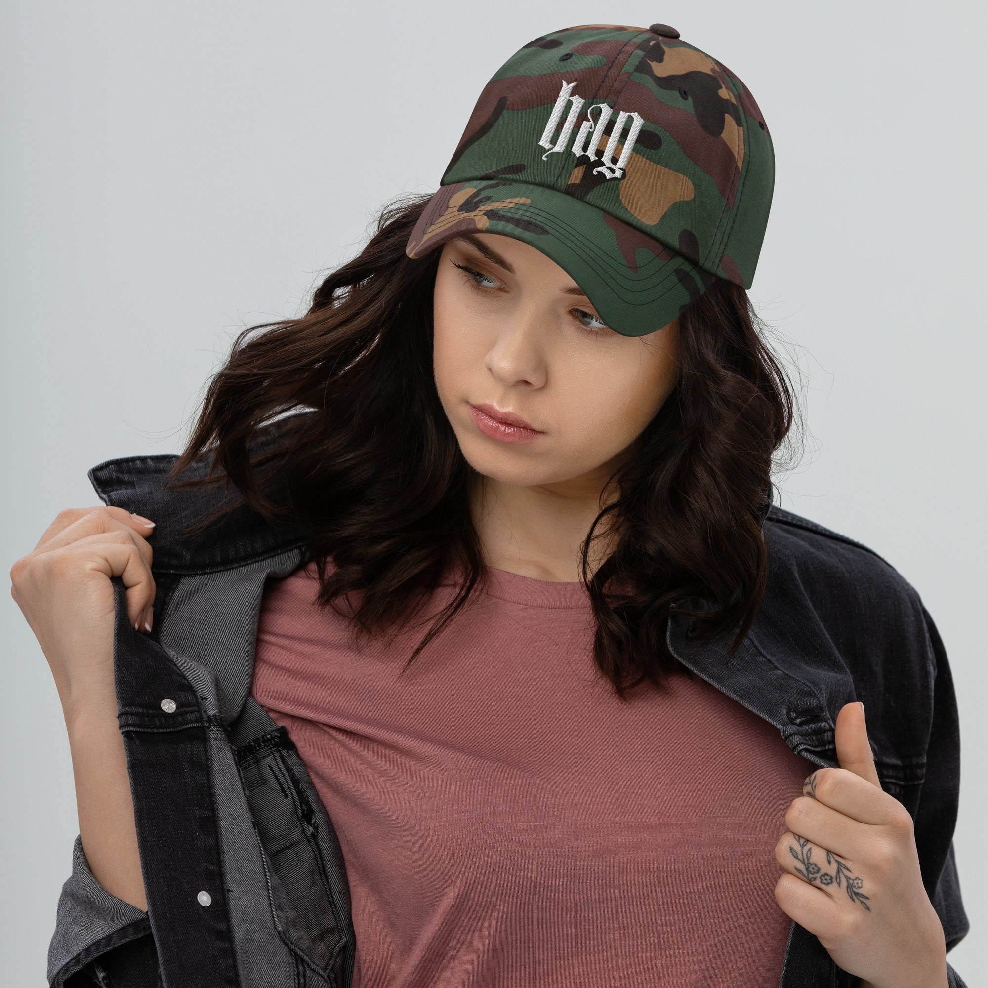 Black dad hat embroidered with the word ‘HAG’ in ornate vintage gothic lettering. Alternative fashion accessory with queer streetwear aesthetic, witchy fashion, sarcastic humor, feminist style, indie fashion, spooky cute apparel, gothic embroidery, punk inspired streetwear, adjustable baseball cap, casual everyday alternative outfit, internet humor fashion, artsy accessory, and edgy statement hat for concerts, festivals, casual wear, and alternative wardrobes.