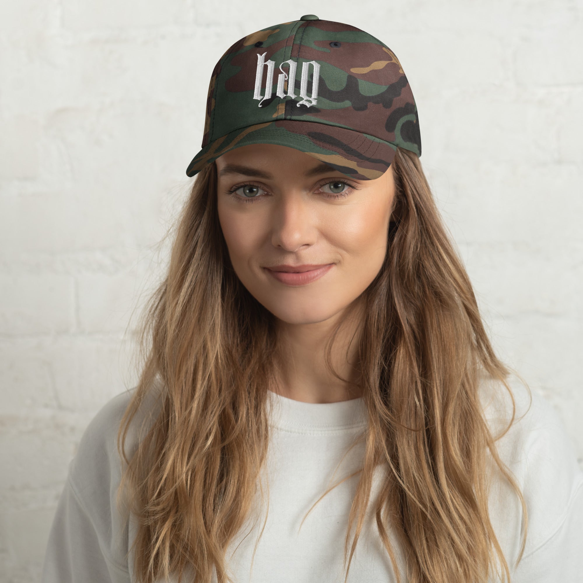 Black dad hat embroidered with the word ‘HAG’ in ornate vintage gothic lettering. Alternative fashion accessory with queer streetwear aesthetic, witchy fashion, sarcastic humor, feminist style, indie fashion, spooky cute apparel, gothic embroidery, punk inspired streetwear, adjustable baseball cap, casual everyday alternative outfit, internet humor fashion, artsy accessory, and edgy statement hat for concerts, festivals, casual wear, and alternative wardrobes.