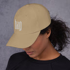 Black dad hat embroidered with the word ‘HAG’ in ornate vintage gothic lettering. Alternative fashion accessory with queer streetwear aesthetic, witchy fashion, sarcastic humor, feminist style, indie fashion, spooky cute apparel, gothic embroidery, punk inspired streetwear, adjustable baseball cap, casual everyday alternative outfit, internet humor fashion, artsy accessory, and edgy statement hat for concerts, festivals, casual wear, and alternative wardrobes.