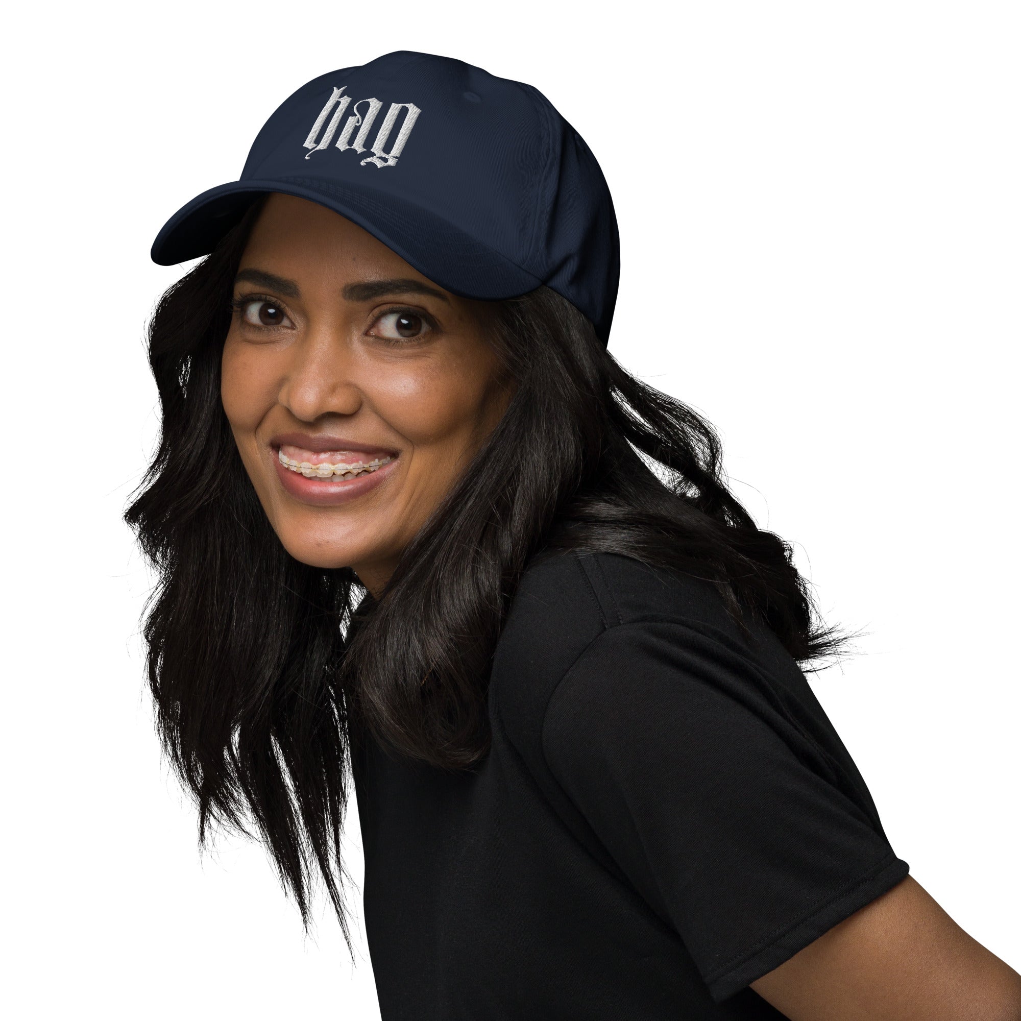 Black dad hat embroidered with the word ‘HAG’ in ornate vintage gothic lettering. Alternative fashion accessory with queer streetwear aesthetic, witchy fashion, sarcastic humor, feminist style, indie fashion, spooky cute apparel, gothic embroidery, punk inspired streetwear, adjustable baseball cap, casual everyday alternative outfit, internet humor fashion, artsy accessory, and edgy statement hat for concerts, festivals, casual wear, and alternative wardrobes.