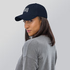 Black dad hat embroidered with the word ‘HAG’ in ornate vintage gothic lettering. Alternative fashion accessory with queer streetwear aesthetic, witchy fashion, sarcastic humor, feminist style, indie fashion, spooky cute apparel, gothic embroidery, punk inspired streetwear, adjustable baseball cap, casual everyday alternative outfit, internet humor fashion, artsy accessory, and edgy statement hat for concerts, festivals, casual wear, and alternative wardrobes.