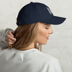 Black dad hat embroidered with the word ‘HAG’ in ornate vintage gothic lettering. Alternative fashion accessory with queer streetwear aesthetic, witchy fashion, sarcastic humor, feminist style, indie fashion, spooky cute apparel, gothic embroidery, punk inspired streetwear, adjustable baseball cap, casual everyday alternative outfit, internet humor fashion, artsy accessory, and edgy statement hat for concerts, festivals, casual wear, and alternative wardrobes.
