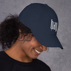 Black dad hat embroidered with the word ‘HAG’ in ornate vintage gothic lettering. Alternative fashion accessory with queer streetwear aesthetic, witchy fashion, sarcastic humor, feminist style, indie fashion, spooky cute apparel, gothic embroidery, punk inspired streetwear, adjustable baseball cap, casual everyday alternative outfit, internet humor fashion, artsy accessory, and edgy statement hat for concerts, festivals, casual wear, and alternative wardrobes.