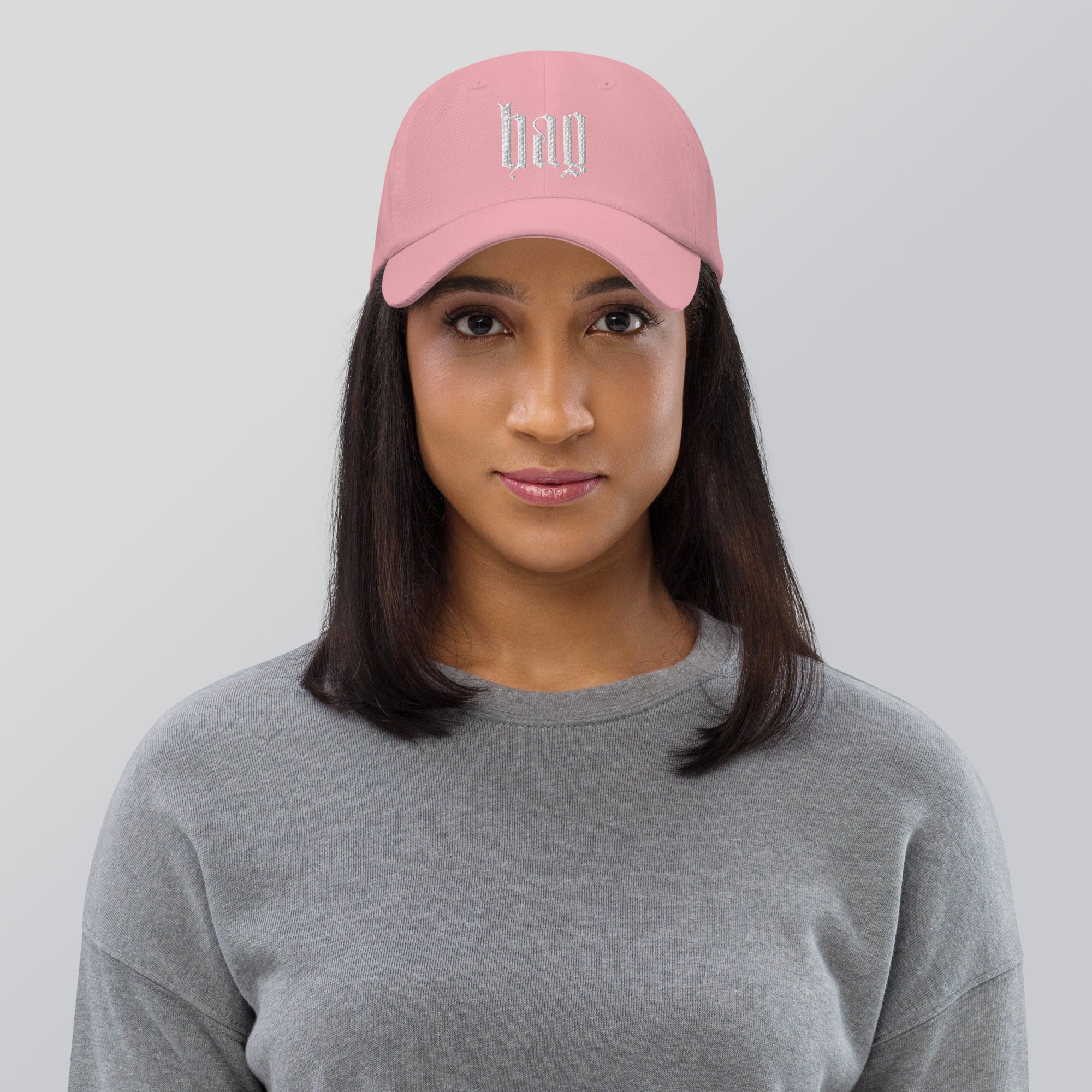 Black dad hat embroidered with the word ‘HAG’ in ornate vintage gothic lettering. Alternative fashion accessory with queer streetwear aesthetic, witchy fashion, sarcastic humor, feminist style, indie fashion, spooky cute apparel, gothic embroidery, punk inspired streetwear, adjustable baseball cap, casual everyday alternative outfit, internet humor fashion, artsy accessory, and edgy statement hat for concerts, festivals, casual wear, and alternative wardrobes.