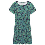 Short sleeve dress featuring the Frondescence pattern with layered tropical foliage in deep green botanical tones and an all-over nature-inspired print. Flowy casual dress with earthy jungle aesthetic, maximalist fashion, indie streetwear, botanical artwork, expressive queer friendly style, artsy everyday wear, and retro-inspired tropical clothing perfect for vacations, brunch, festivals, casual outings, and comfortable everyday alternative fashion.